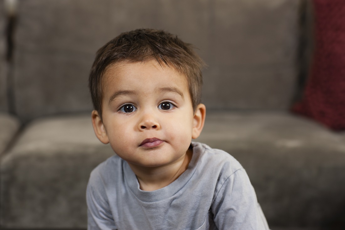 Philadelphia,,USA,A young boy sitting looking at the camera with a serious expression.